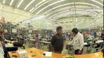 Il teste sa veste pare-balles devant les ouvrières de l'usine