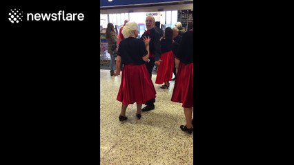 Baby utterly enthralled by singers in supermarket