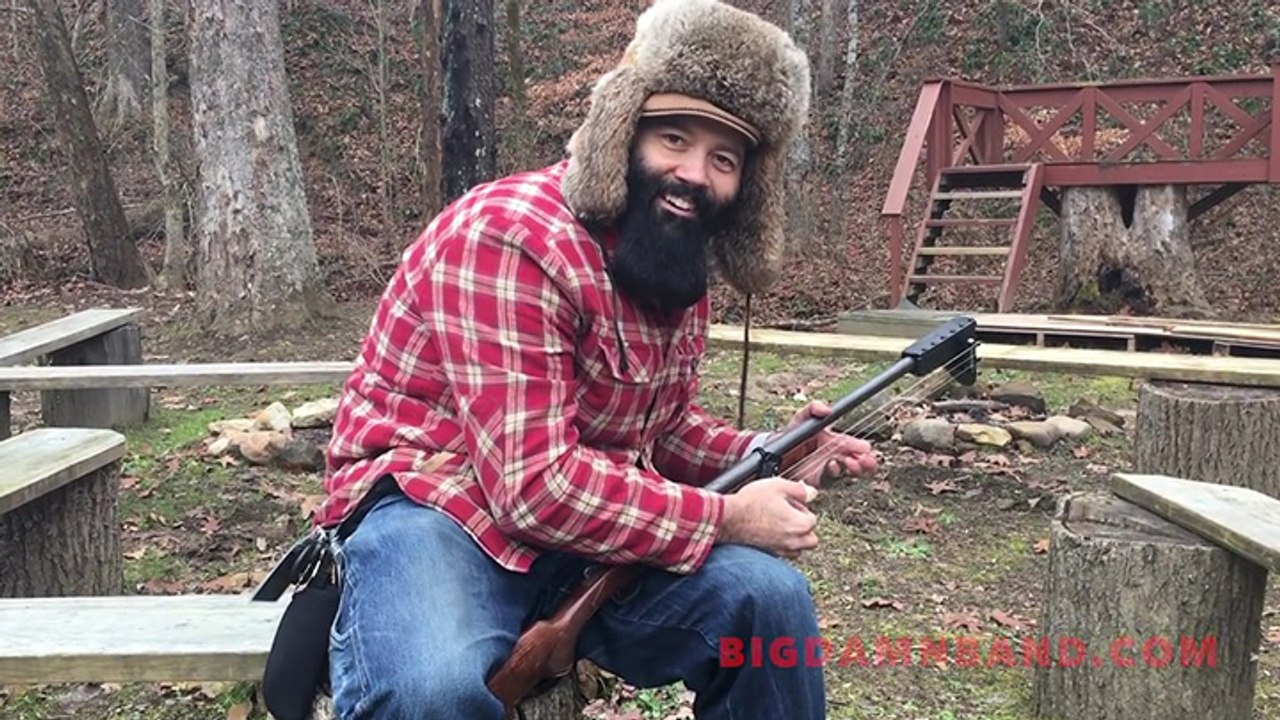 Il joue de la guitare avec un fusil