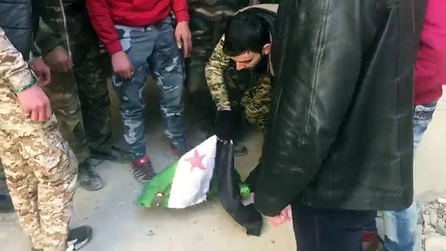 Сирийский солдат сжигает и топчет флаг сирийской оппозиции