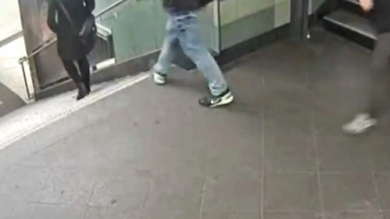 Un homme donne un coup de pied dans le dos d'une femme qui descend les escaliers