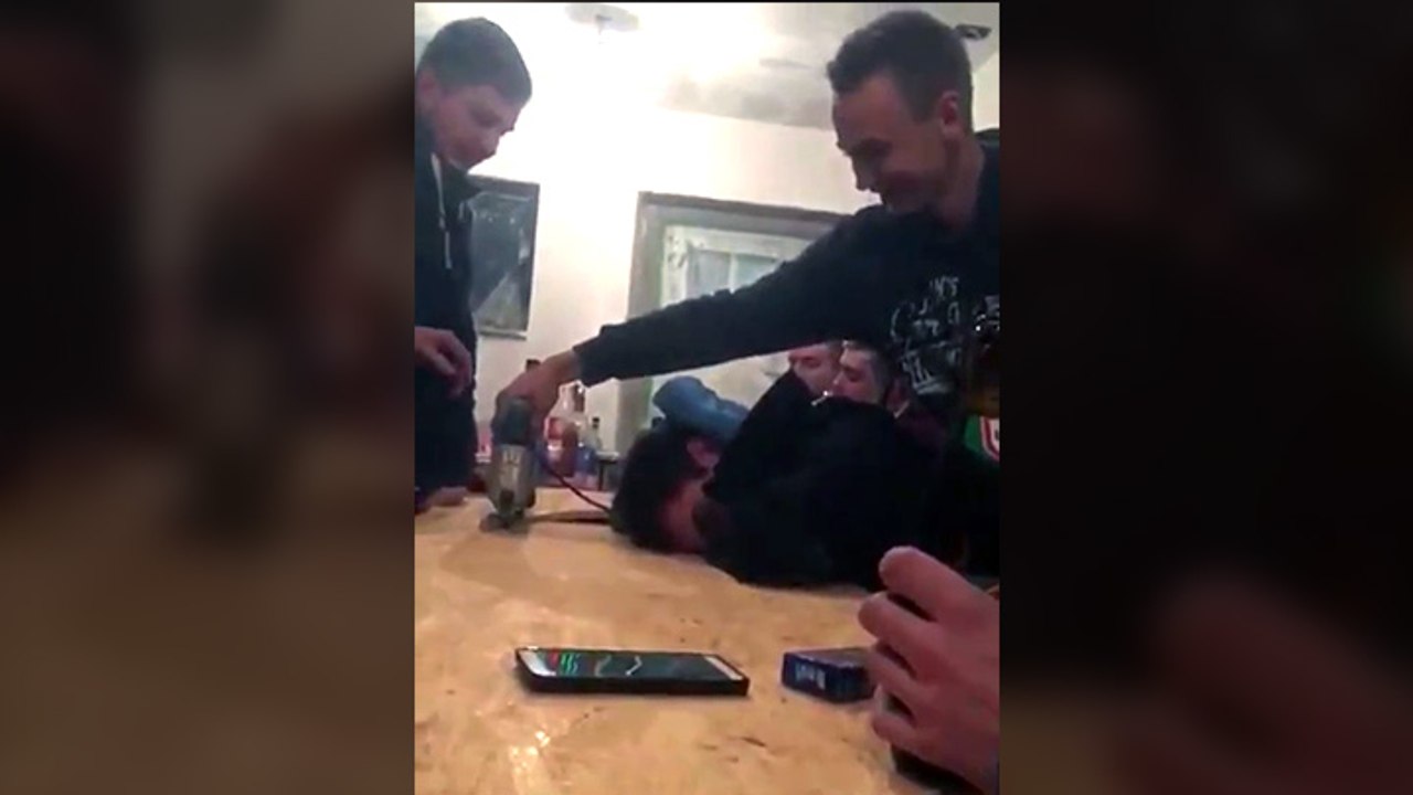 Blague de la scie sauteuse sur un mec qui dort sur une table en bois