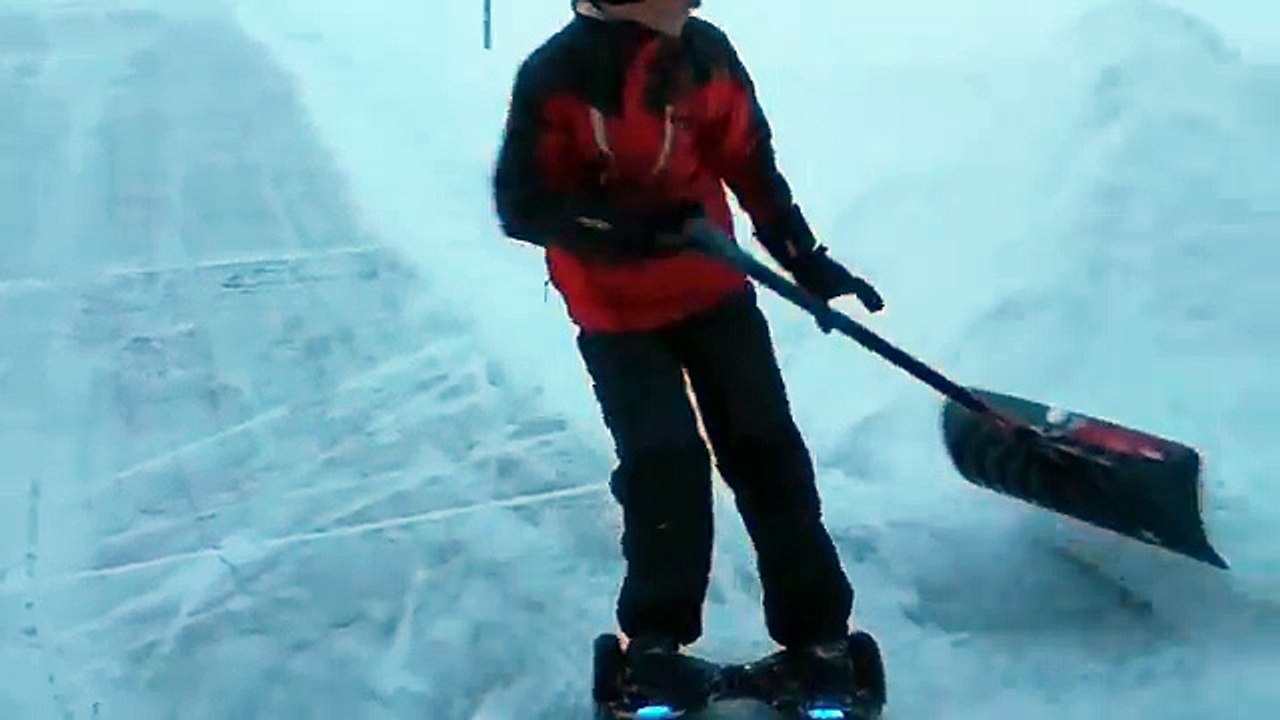 Un jeune deneige devant chez lui en hoverboard