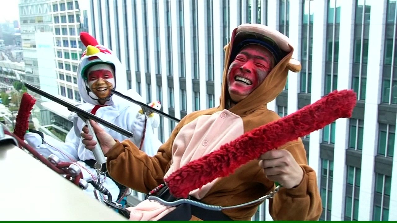 A monkey and a rooster clean windows in Tokyo