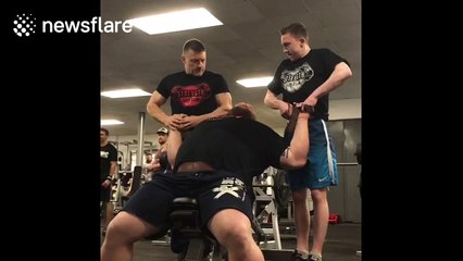 Weightlifter bench presses two large men