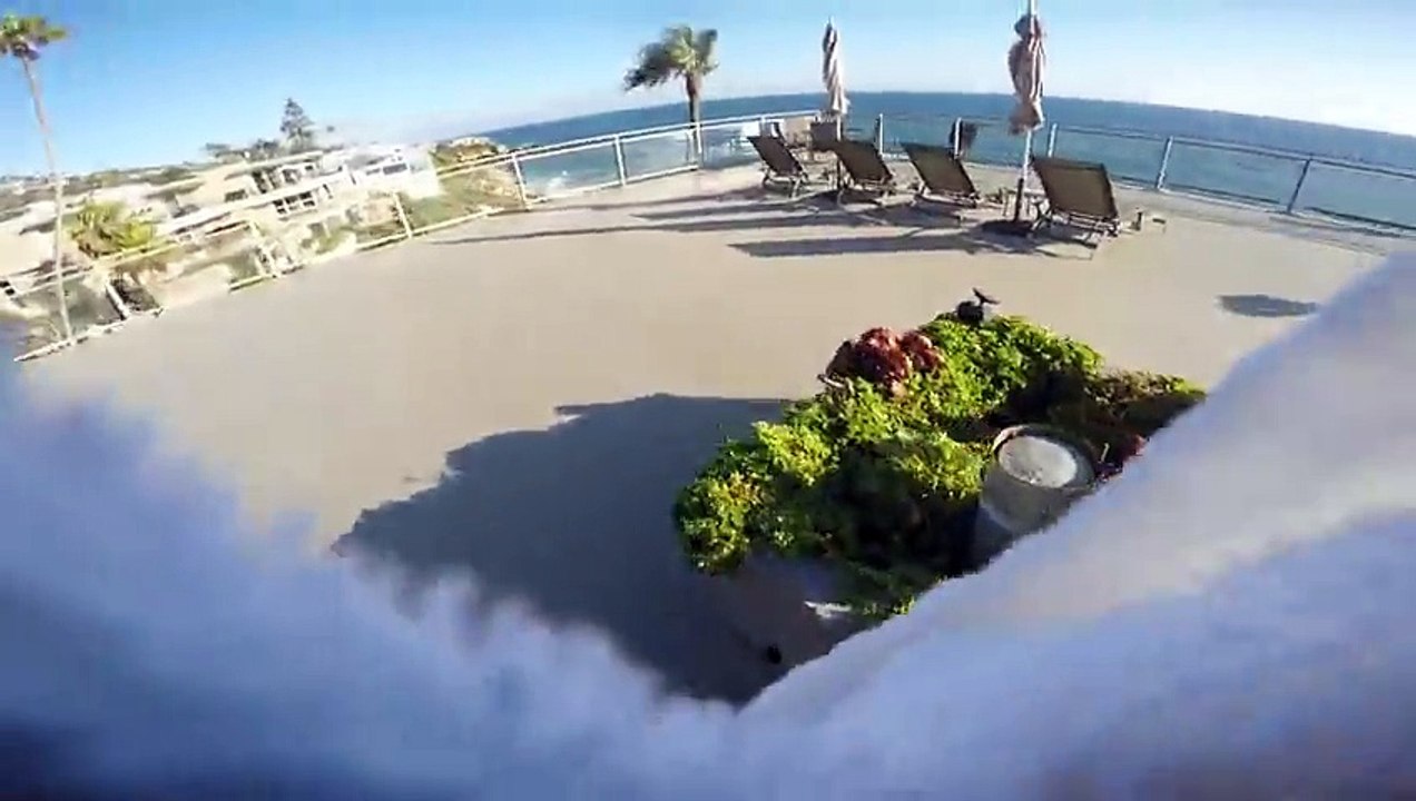 Il plonge dans la piscine à partir d'un toit d'hôtel