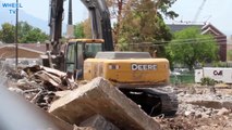 Deere 270D excavator digging and moving debris from a torn down building on a cosntruction site
