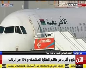 أحد مختطفى الطائرة الليبية يلوح بعلم نظام "القذافى" بعد الإفراج عن الركاب