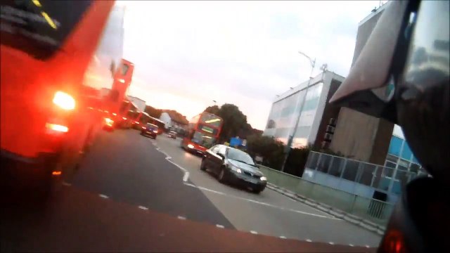 CAR REARING CYCLIST ON BROW OF HILL