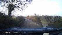 Motorist drives down country lane with bonnet up