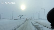 Snow blown on road creates wave-like patterns