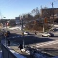 Une tarée saute sur une voiture de police à un croisement.