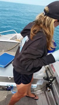 platrée d'un bras, elle pêche avec l'autre et attrape un gros poisson