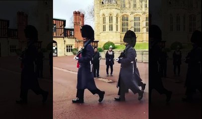 un garde royal accorde une photo à une petite fille
