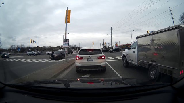 Un piéton se fait percuter par une voiture à un croisement.