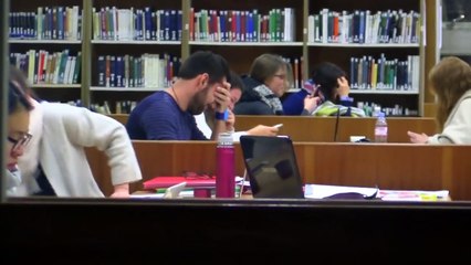 Il fait semblant de mal brancher ces écouteurs en plein milieu d’une bibliothèque universitaire