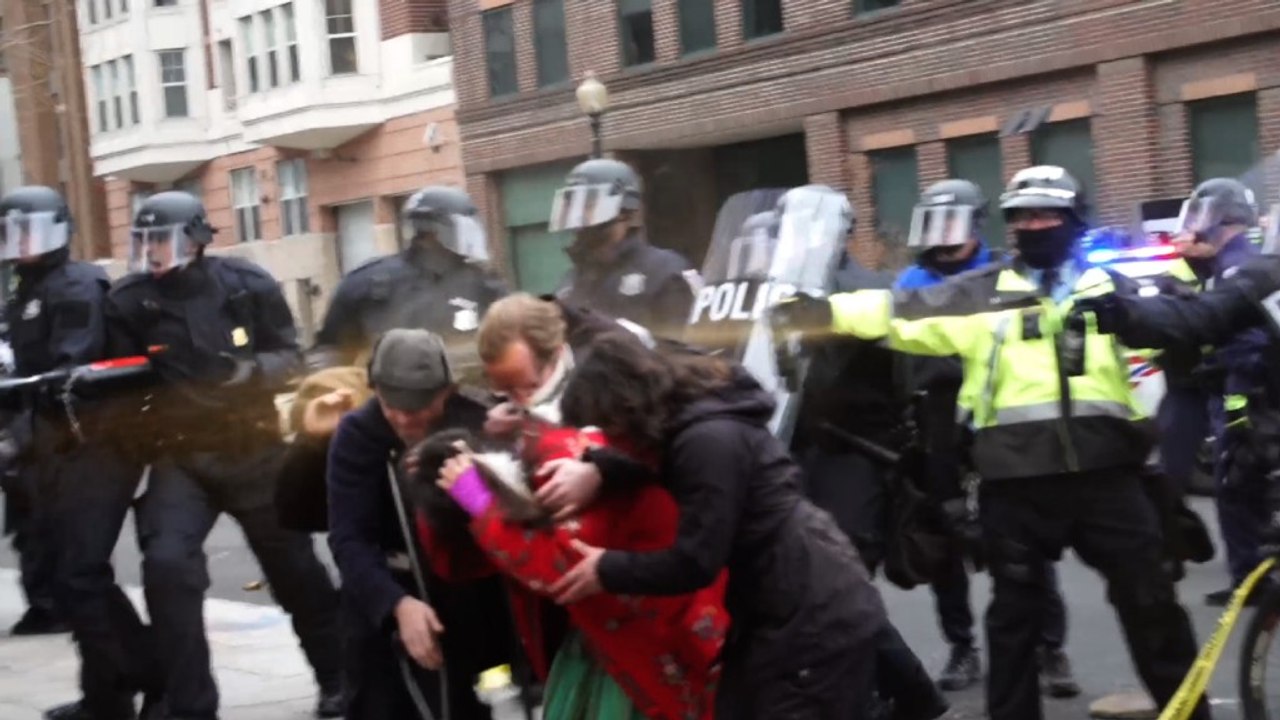 Police in riot gear emit chemical spray on protesters