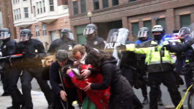 Police in riot gear emit chemical spray on protesters