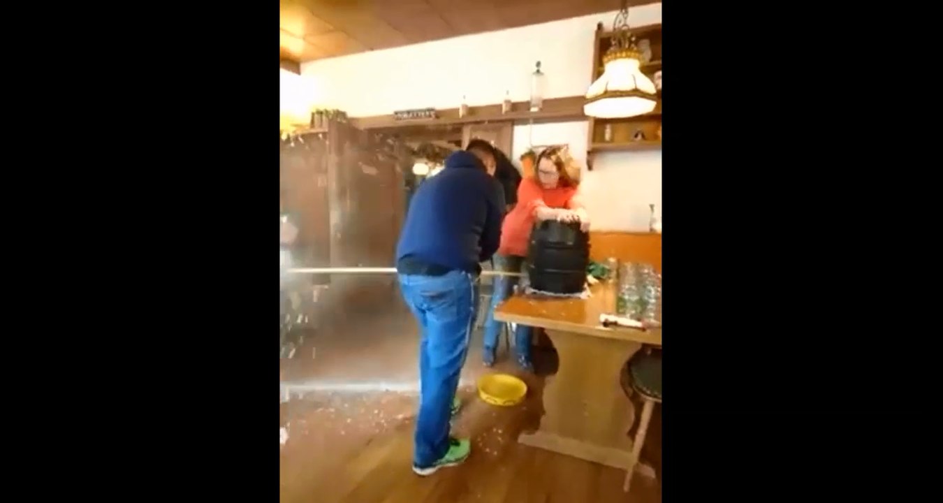 Il essaye d'ouvrir un fût de bière avec un marteau.
