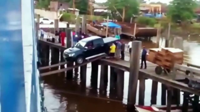 Pickup truck loading onto a ship over some planks