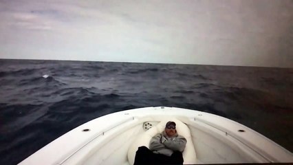 Un homme allongé sur un bateau se prend une grosse vague !