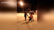 Dad ice skates while pushing baby in pram