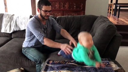 Baby unable to stand on his feet can balance on father's hand