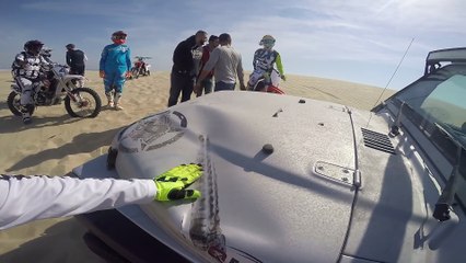 Une moto atterrit sur une Jeep dans le désert