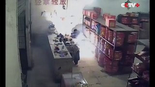 Un homme allume des feux d'artifices devant une boutique de feux d'artifice