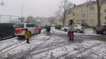 Un policier fait une bataille de boules de neige avec des enfants
