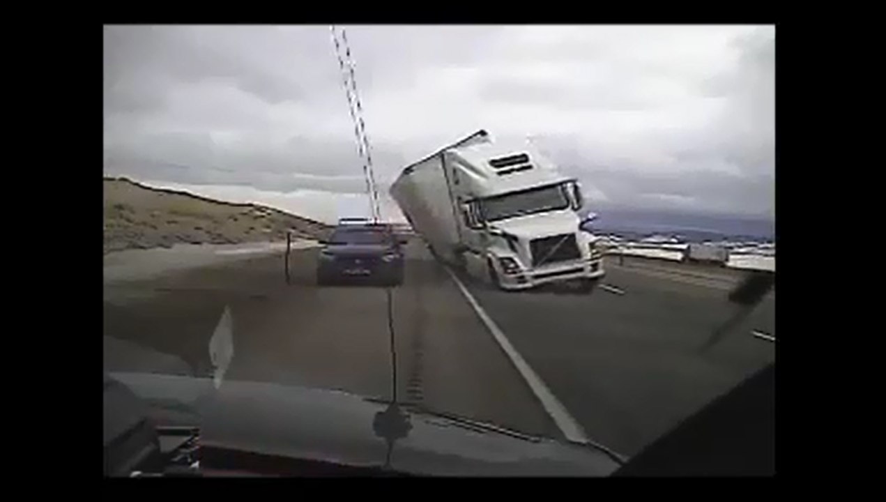 Une rafale de vent renverse un camion sur une voiture de police.