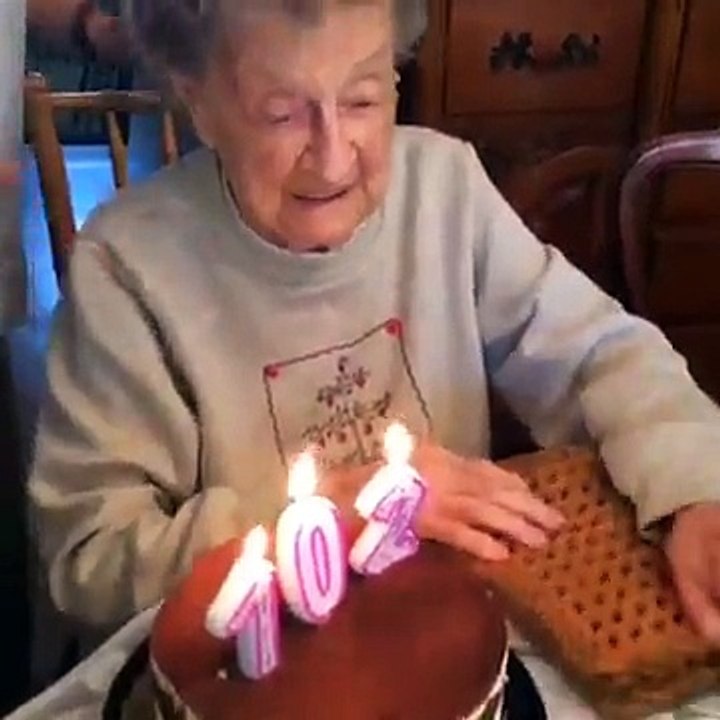 a lady cutting her 102th birthday cake