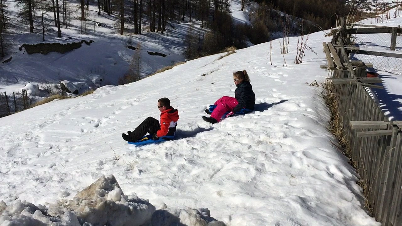 Descente en luge devant la maison avec rire des spectateurs