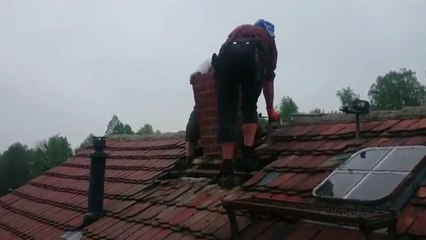 Deux abrutis essayent d'enlever une cheminée sur le toit d'une maison