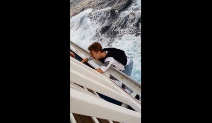 Un jeune suspendu dans le vide au-dessus de l'eau.