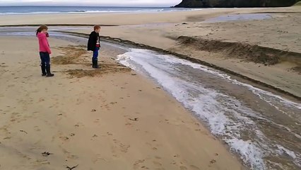 Leur papa leur construit un mini barrage sur la plage... Incroyable!