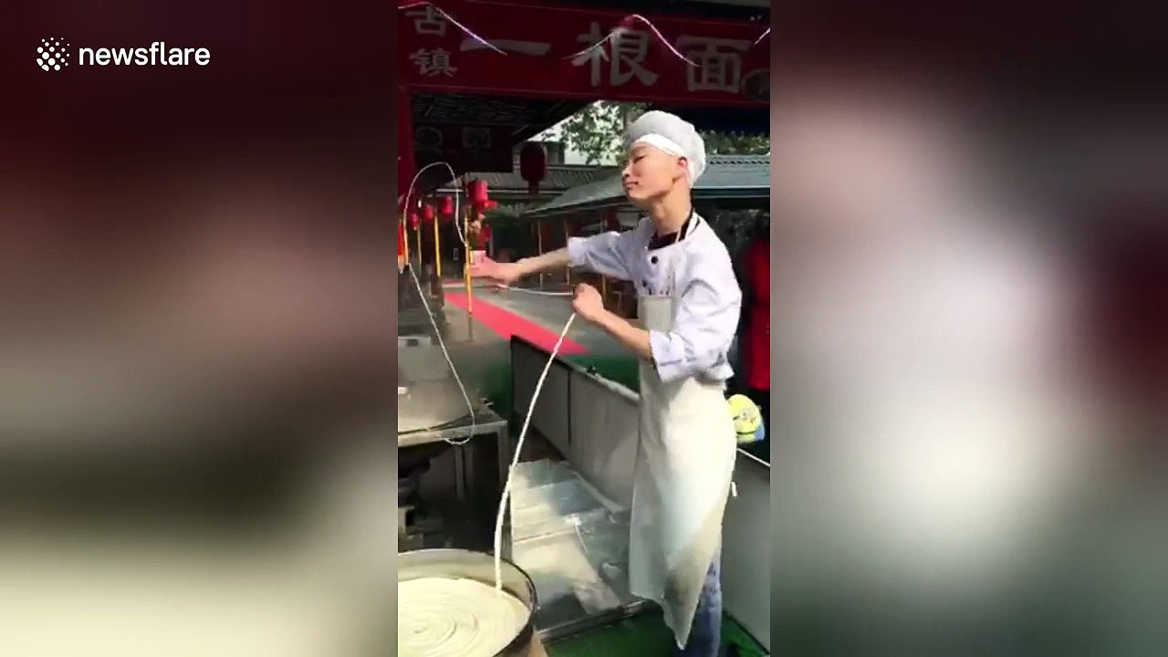 Enthusiastic man dances while he pulls one-strand noodle