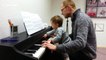 Adorable one-year-old baby plays piano with her dad