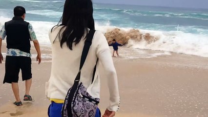 Un enfant emporté par une vague