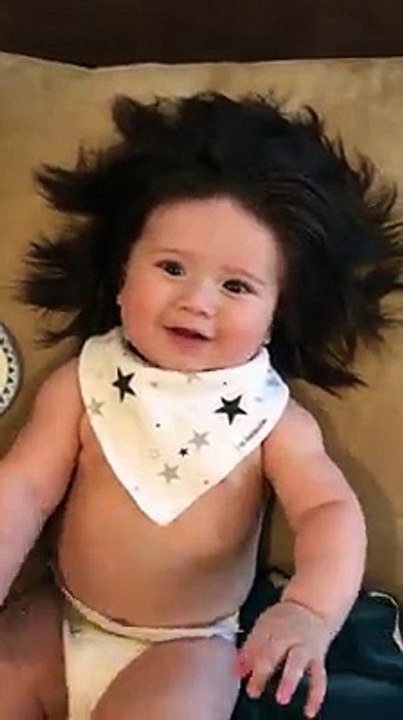 Un bébé de 7 mois avec des cheveux longs