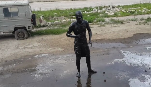 Un homme plonge dans un bassin d'huiles de vidange