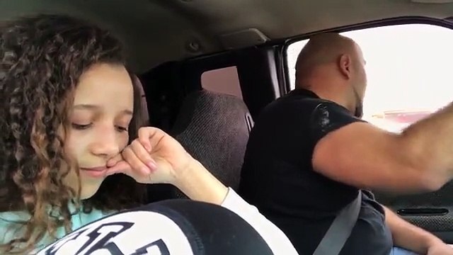 The daughter takes her father as he sings in the car. His voice is creepy!