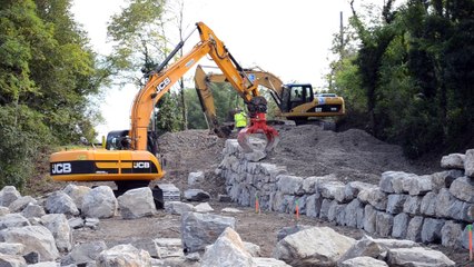 La confection du mur de soutien pour la pause d'une passerelle en bois