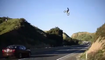 Un pilote saute en motocross au-dessus d'une autoroute.