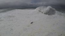 Double chute pour ce surfeur prenant une vague géante à Nazaré, secouru par un jet ski qui va aussi chuter.