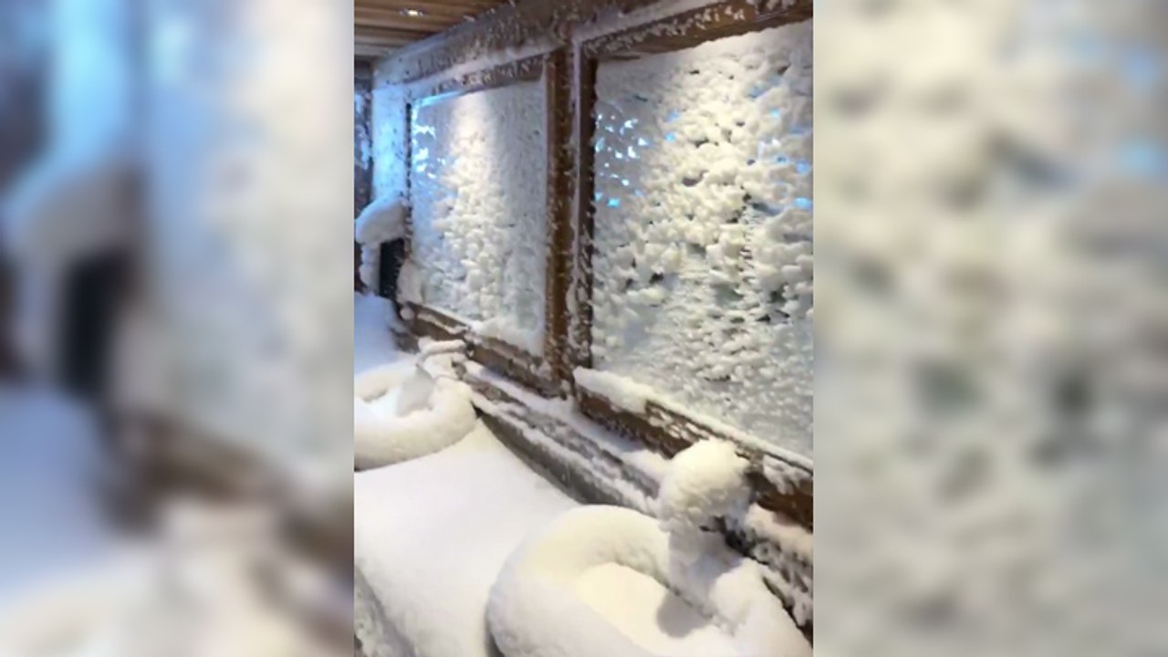 La neige s'infiltre par une fenêtre ouverte dans un restaurant
