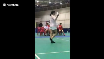 Woman performs keepie uppie tricks with shuttlecock