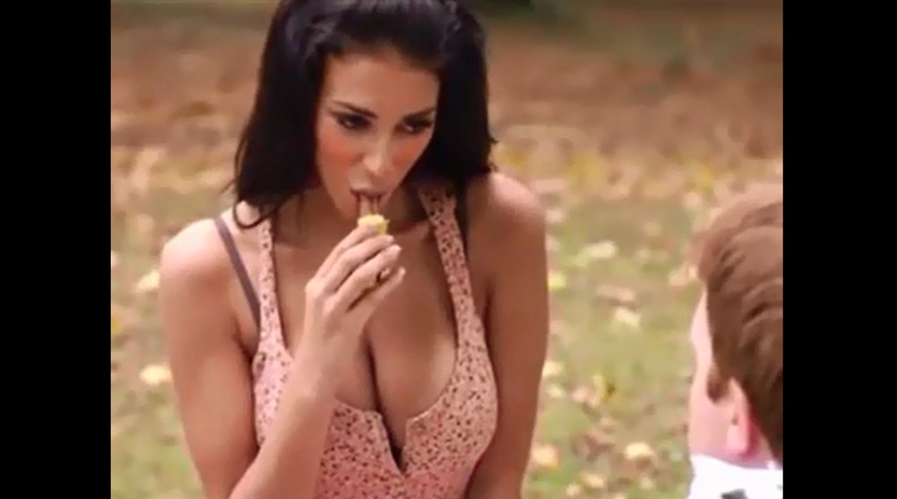 Un jeune fille mange une barre chocolatée devant un enfant.