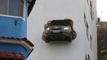 Cette voiture se retrouve encastrée dans le mur d'un immeuble, au 2eme étage. Comment c'est possible??