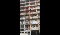 Un jeune escalade les balcons d'un immeuble pour récupérer un ballon.